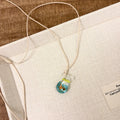 Women's joker charm pendant necklace in coloured glaze on a cotton and linen clavicle chain.
