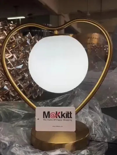 White heart-shaped LED lamp with warm glow on wooden surface