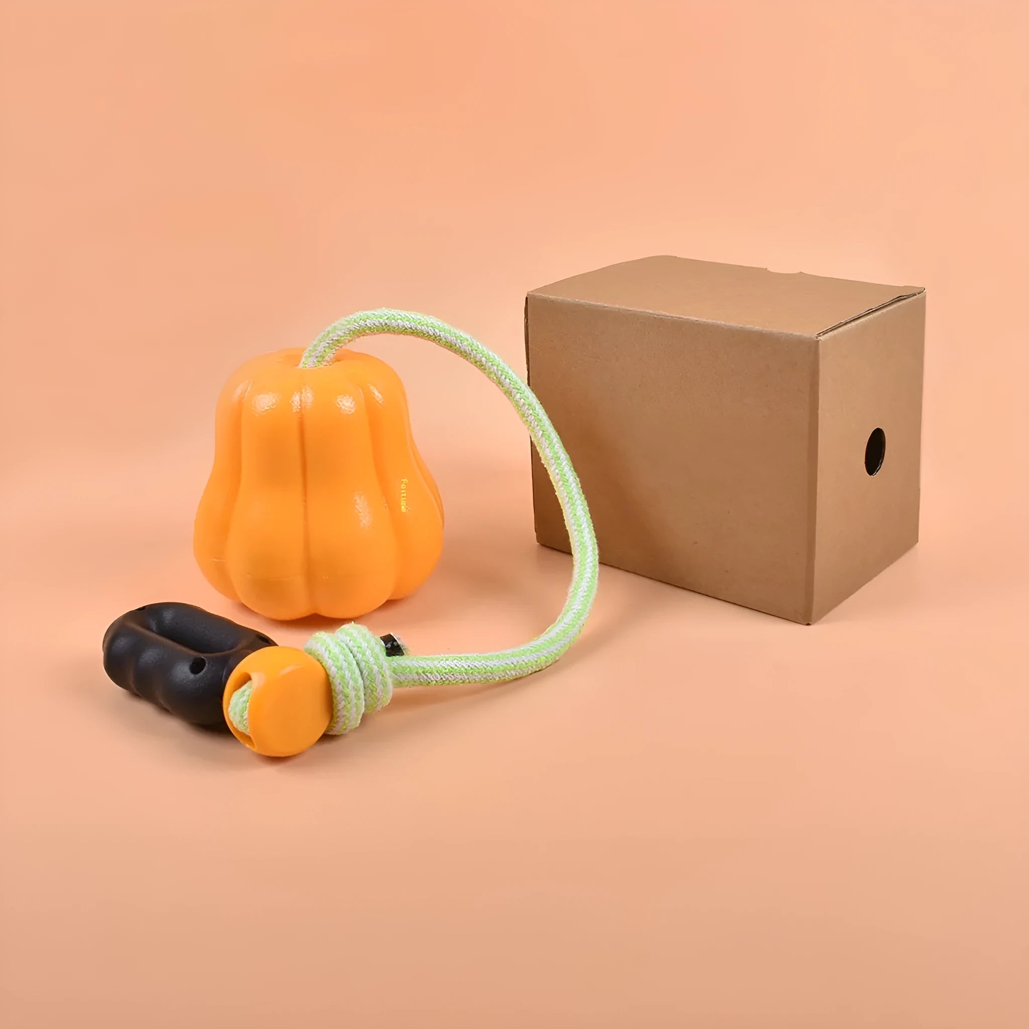 Orange pumpkin-shaped plastic dog chew toy with attached rope handle for large breed dogs