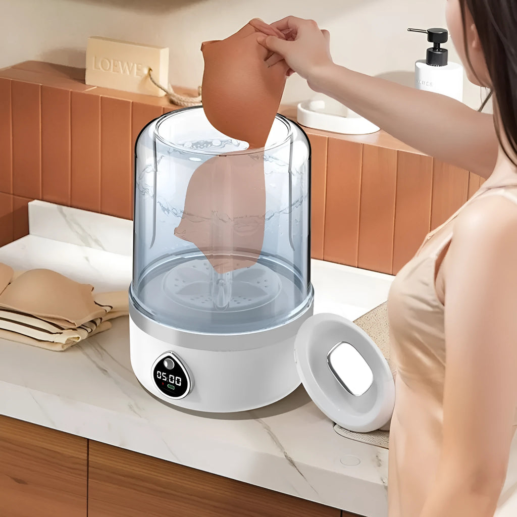 White plastic portable mini washing machine with USB cable on a countertop.