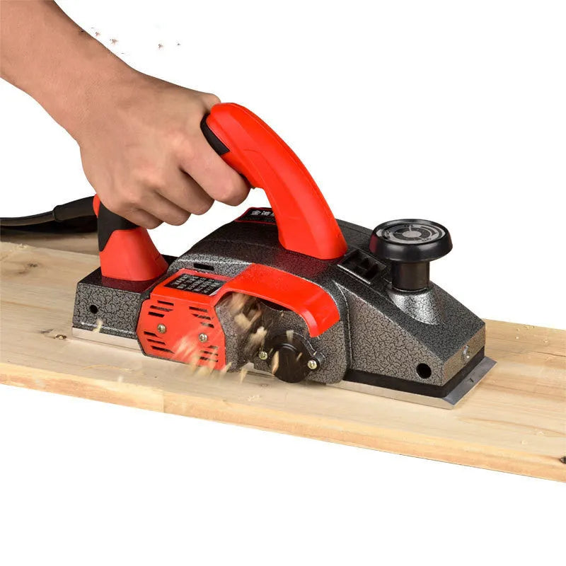 Red aluminium-shell electric wood planer with 82mm planing width on workbench