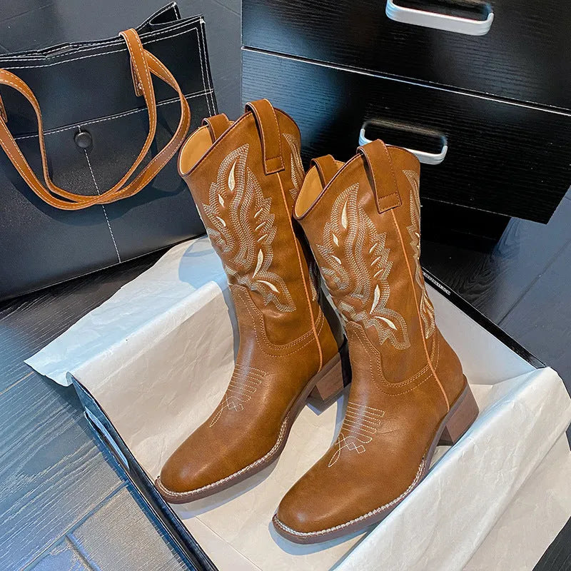 Brown women's mid-calf Martin boots with embroidered pattern, leather lining, and a lace-up front.