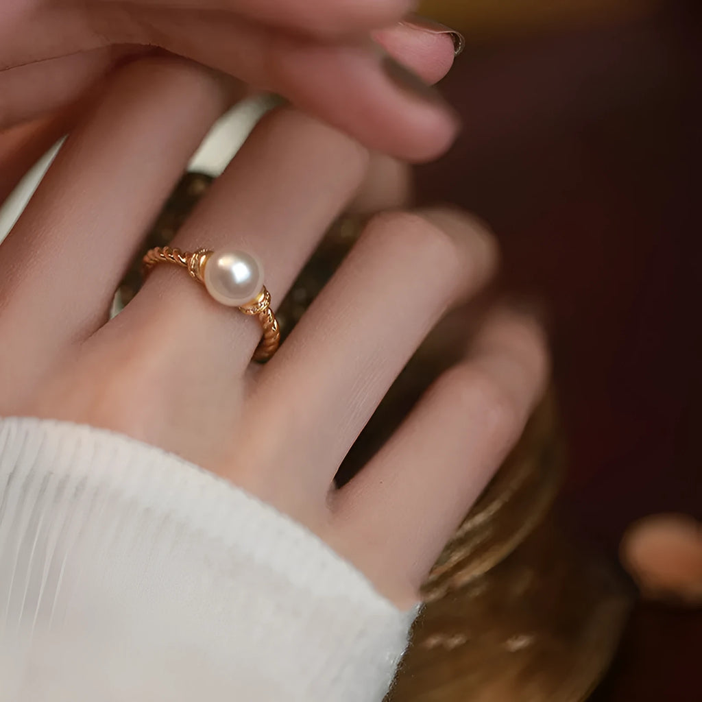 Adjustable copper ring with geometric twist design and pearl inlay in gold colour