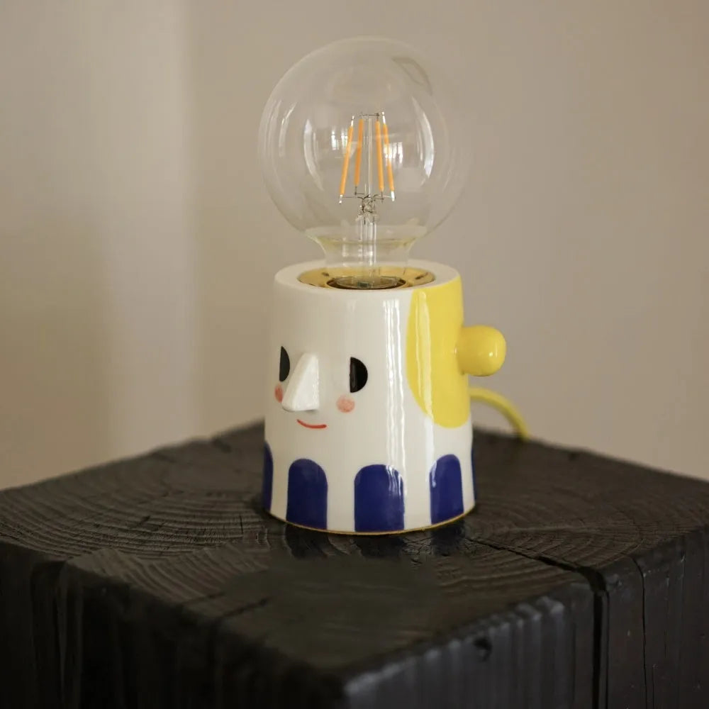 Handmade ceramic bedside lamp with spherical ball headlight shade on wooden nightstand