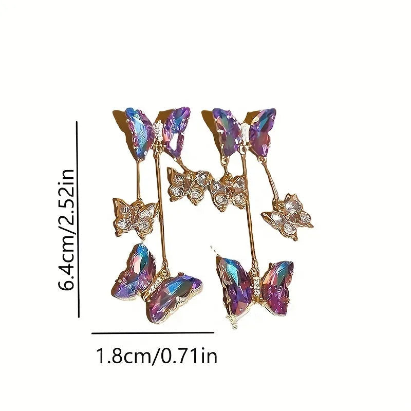 Close-up of women's silver needle blue purple butterfly alloy earrings with crystal flowers and a dangle tassel.