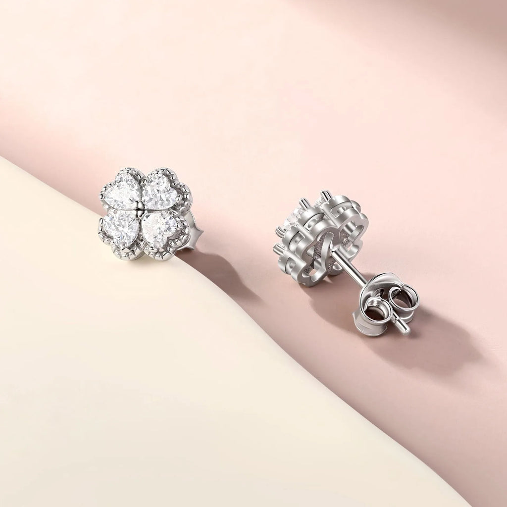 Close-up of women's 925 silver drop earrings with a four-leaf clover charm and heart zircon, in white gold colour.