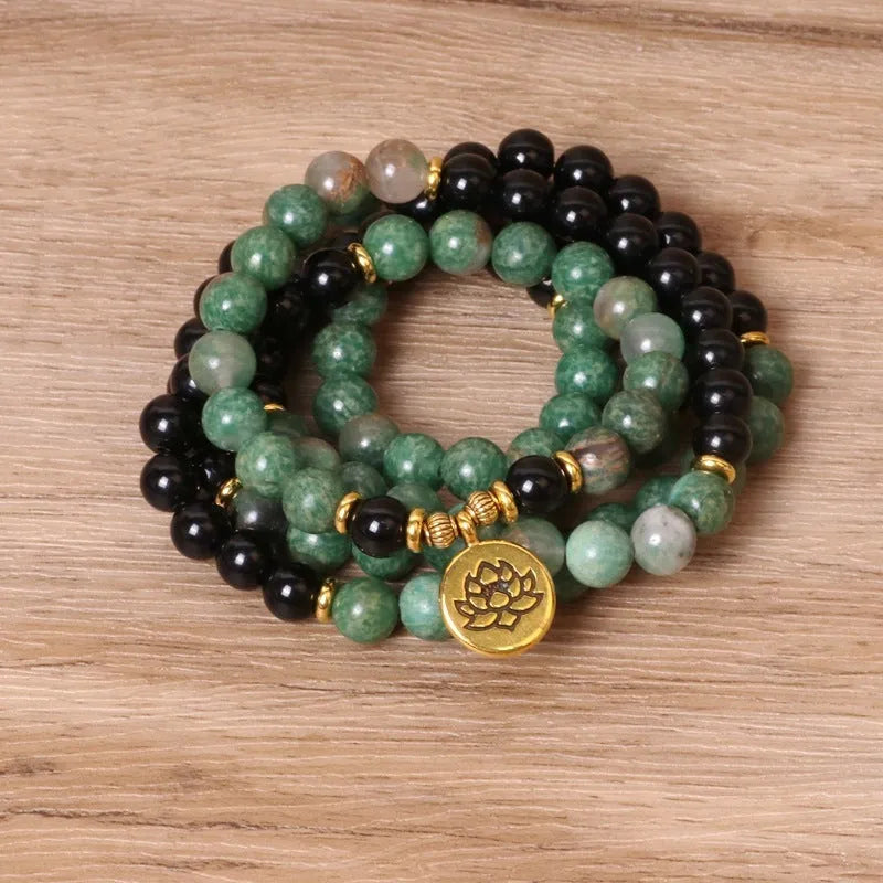 Green and black alloy elastic beaded bracelet with charm decorations on a stretch band.