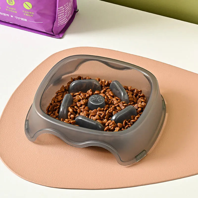 Blue plastic slow-feeder dog bowl on a wooden floor.