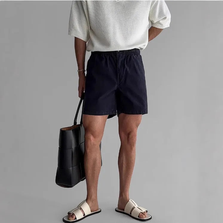 A pair of loose-fit cotton sports shorts in black, shown on a white background.
