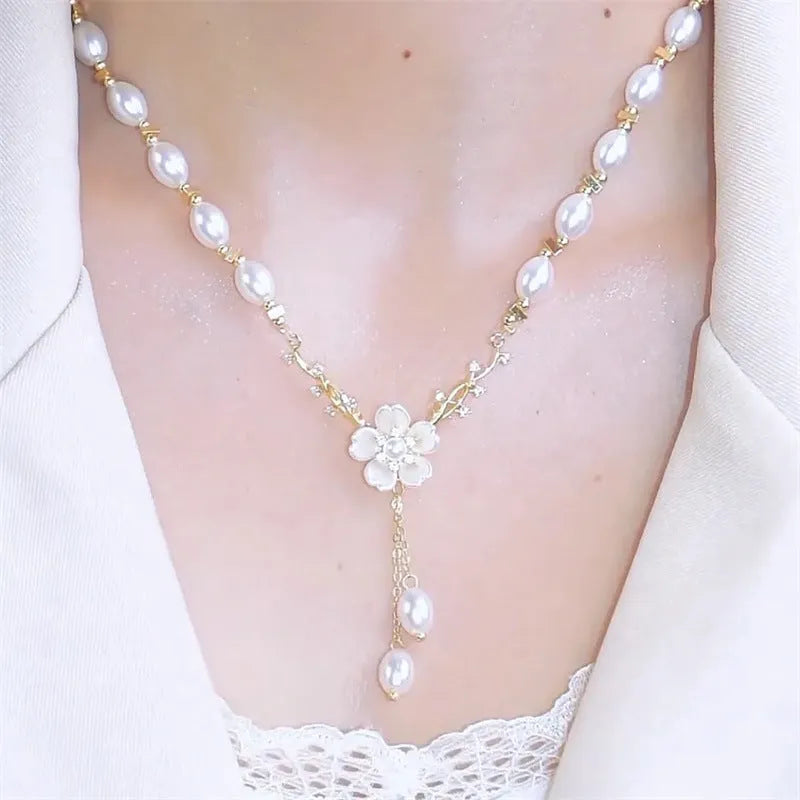 Women's alloy necklace with a white pearl flower and rose design pendant on a chain.