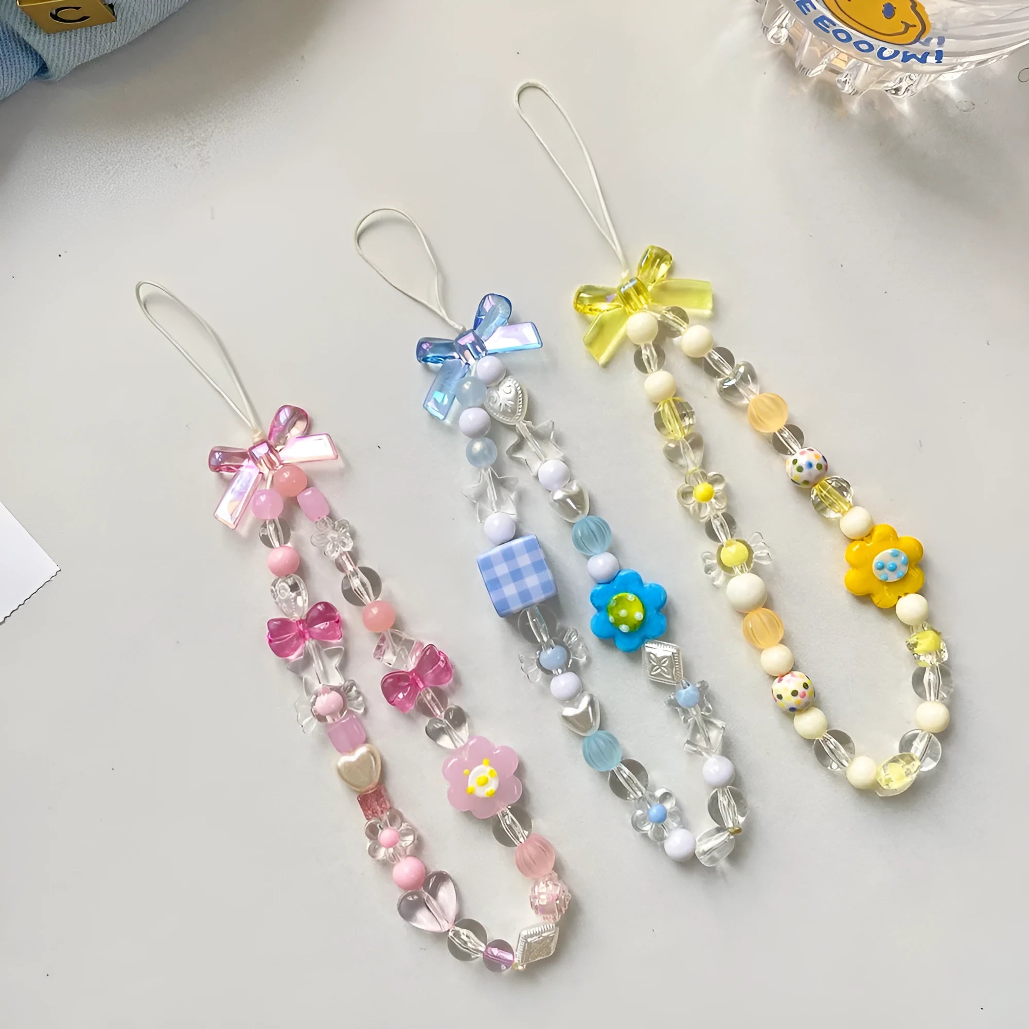 Plastic beaded mobile phone lanyard with floral charms in blue, pink or yellow colour options