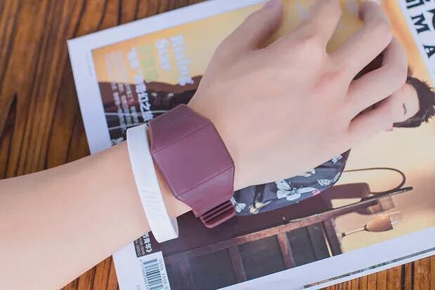 Square plastic electronic watch with digital display on a coloured PU strap, showing touch screen and button controls.