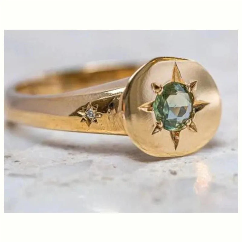 Gold tone adjustable ring with oval band and star-shaped zircon stone.