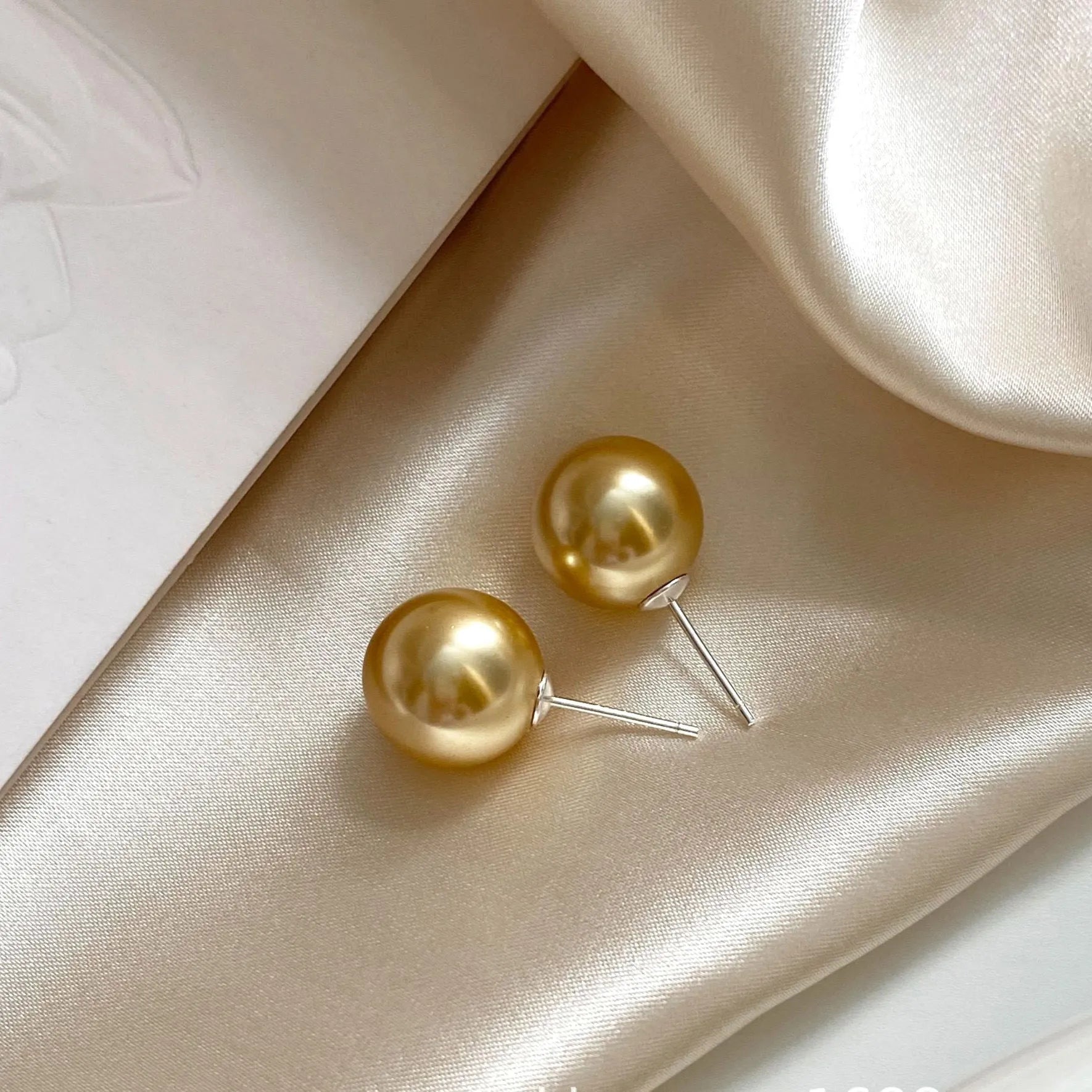 Large geometric pearl stud earrings with an Awn star setting in silver, shown in different size options.