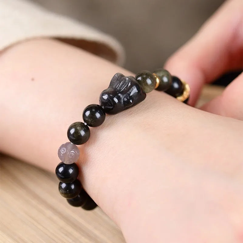 Handmade national style bracelet with lying rabbit Jin Yaoshi charm on neutral background, 8mm beads