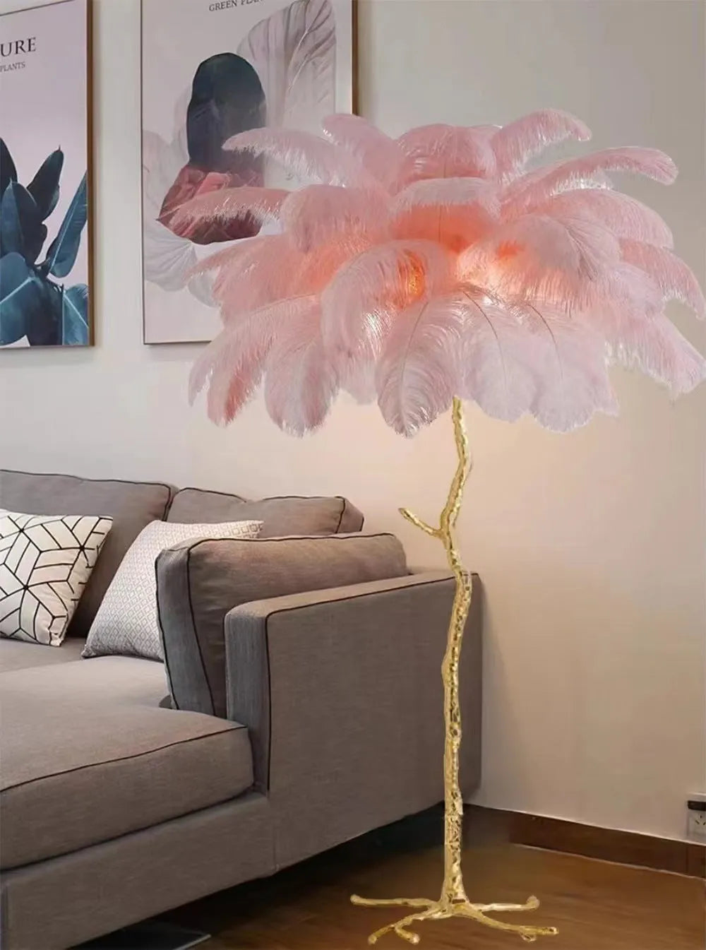 Tall decorative floor lamp with a cluster of white resin feathers next to a sofa.