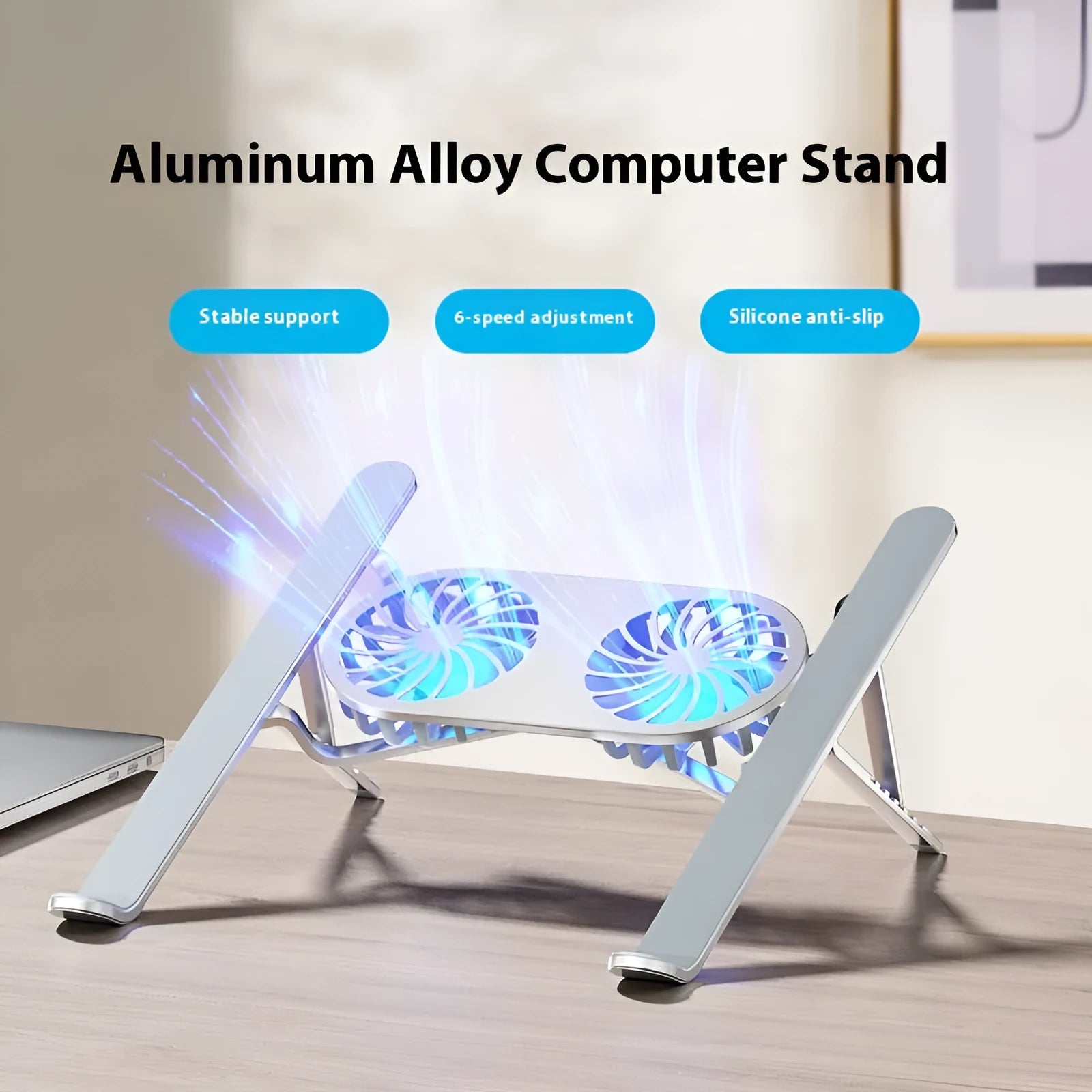 Silver aluminium laptop stand with twin cooling fans in folded position beside notebook computer