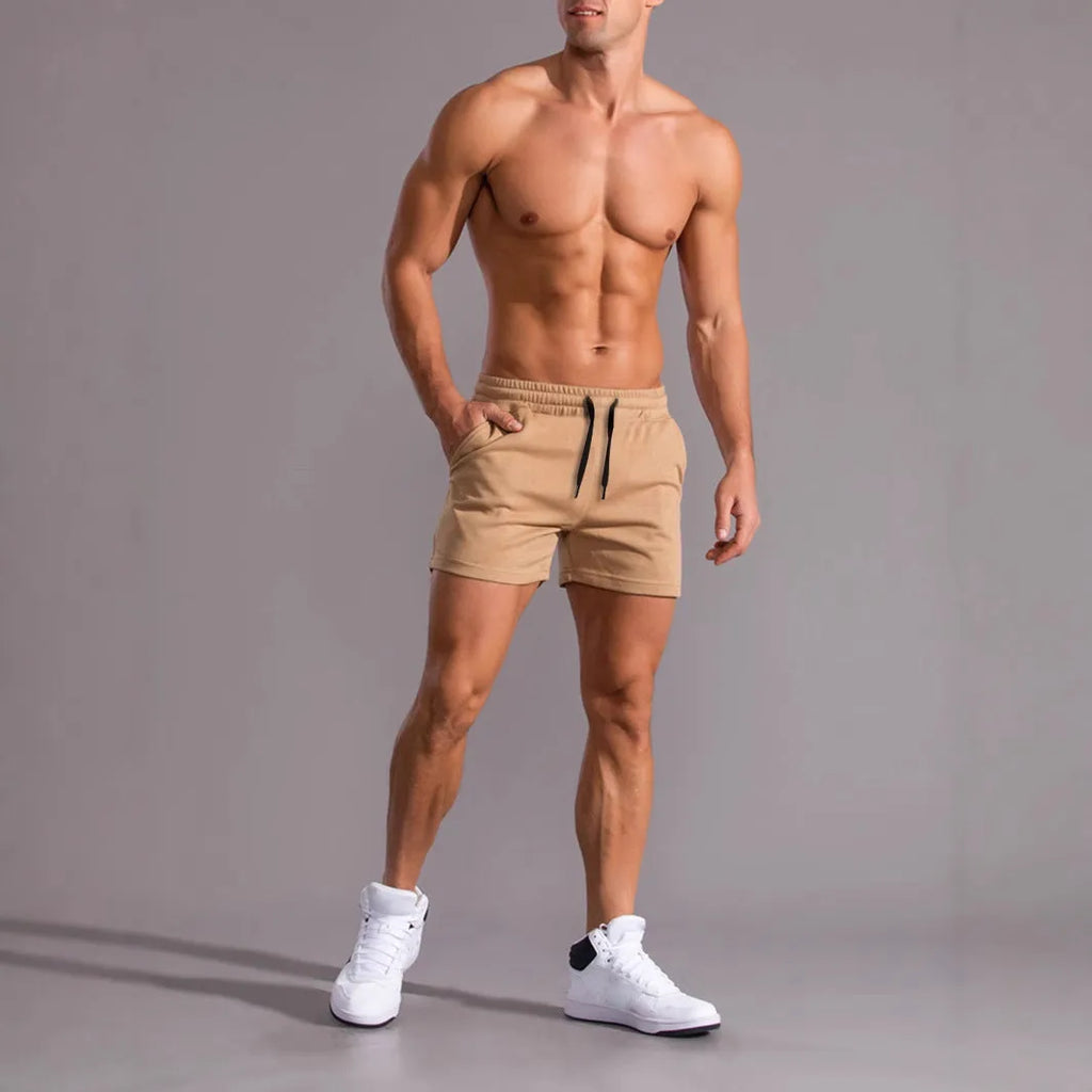 Three men's drawstring shorts in black, khaki and light brown laid flat, showing elastic waistband and loose leg design.