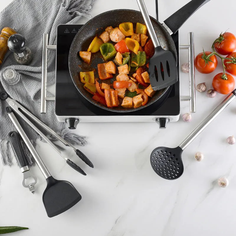 Black silicone kitchen utensil set of 16 pieces including spatulas and spoons on a countertop