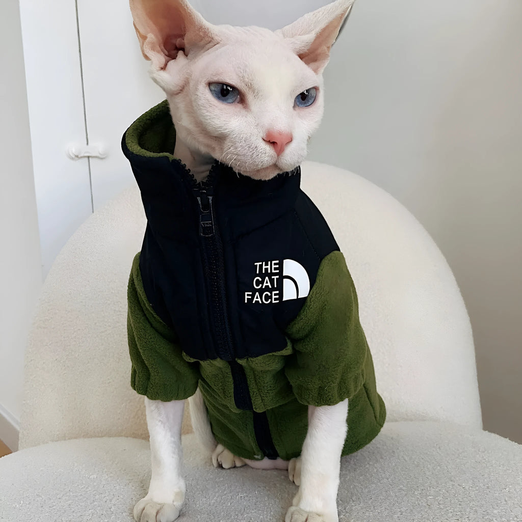 Hairless cat wearing a coral fleece jumpsuit in army green, side view on neutral background