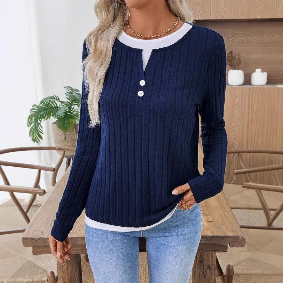 Women's black fake two-piece pullover sweater with a round neck and a button on the shoulder.