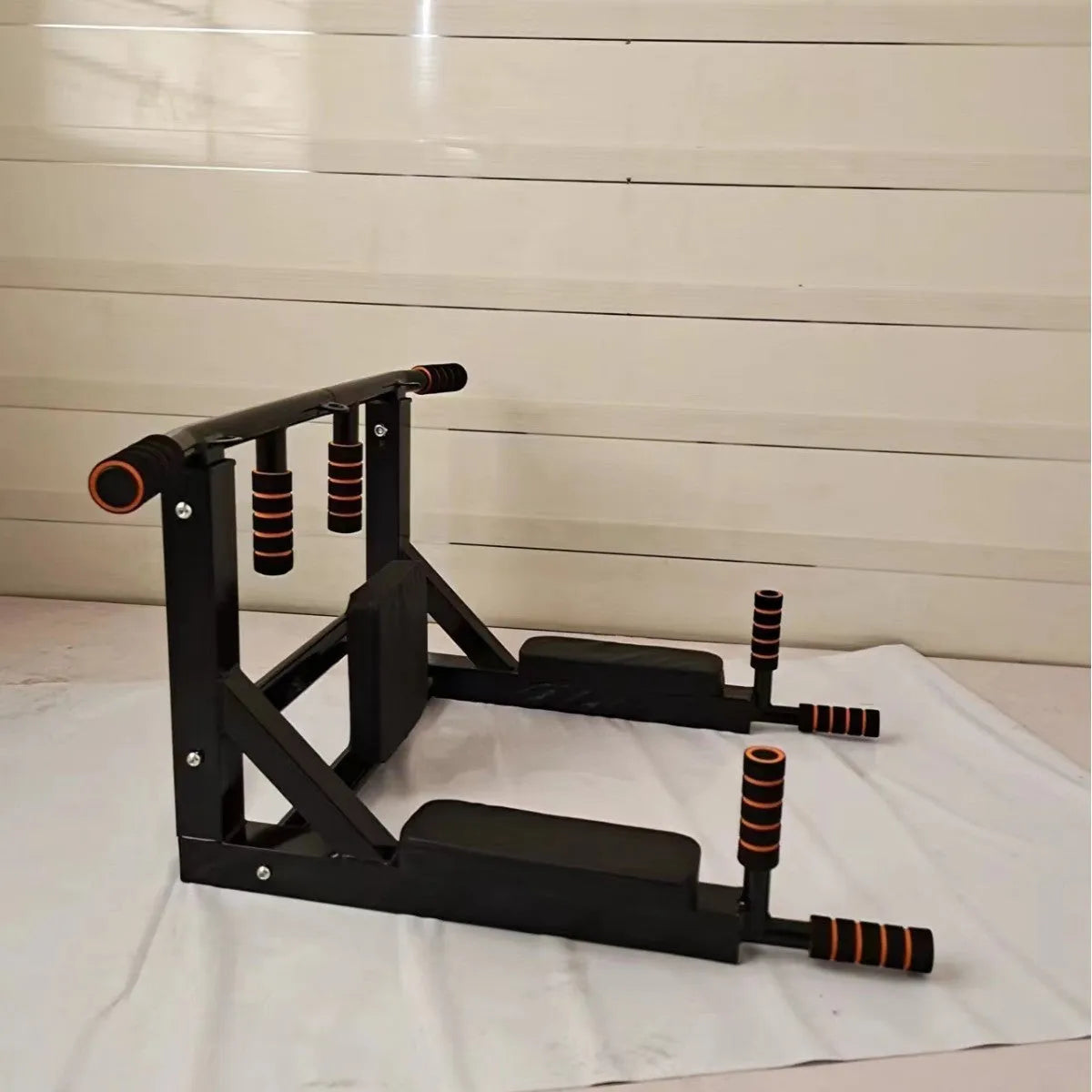 Black wall-mounted metal fitness station with sandbag rack and integrated parallel bars for pull-ups.