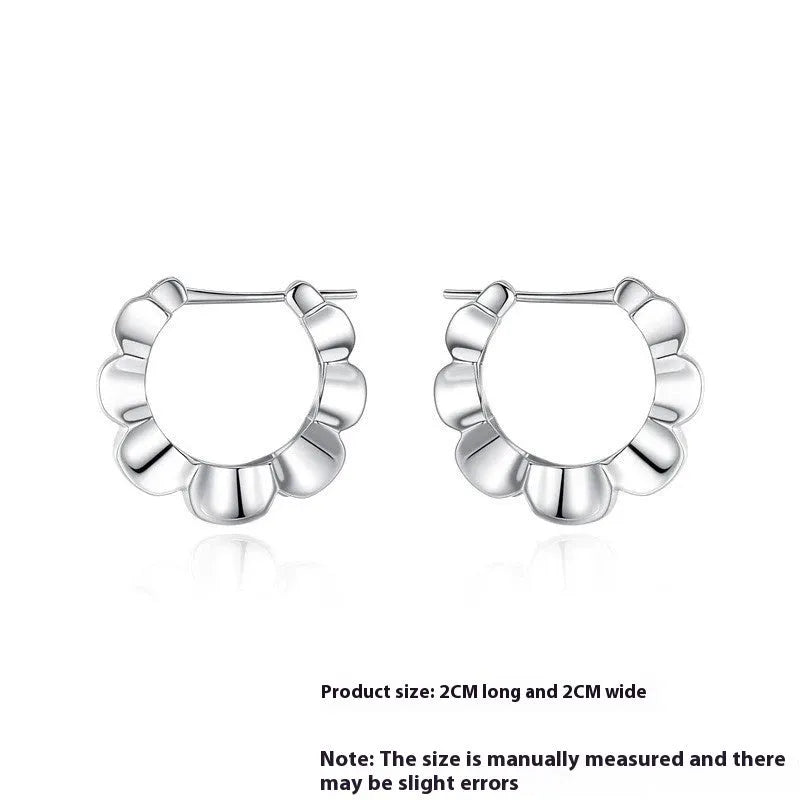 A pair of sterling silver geometric earrings with round elements on a white background.