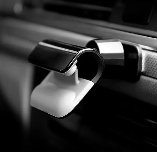Black universal car phone holder with 360-degree rotation mounted on car dashboard holding smartphone