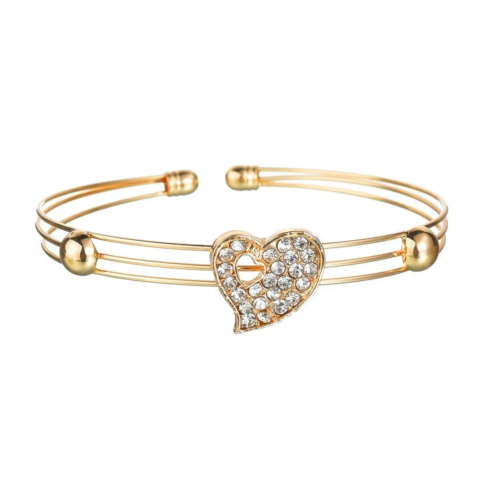Women's gold alloy jewellery set with earrings, necklace featuring love pendant, and matching bracelet