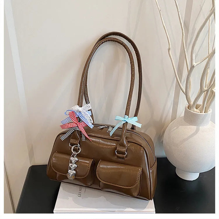Retro brown PU leather women's pillow bag with double shoulder straps and a flap top closure.