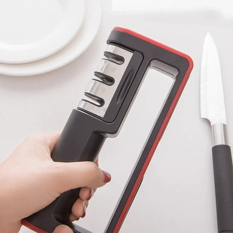 Black and red three-stage knife sharpener with non-skid rubber feet on a worktop