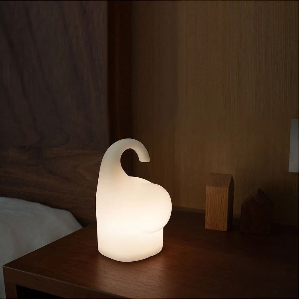 Soft silicone elephant night light with warm white LED glow on bedside table