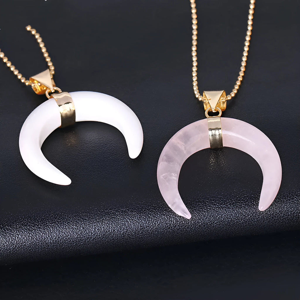 Close-up of a moon-shaped pendant necklace made from pink natural crystal stone on a 45cm electroplated copper chain.