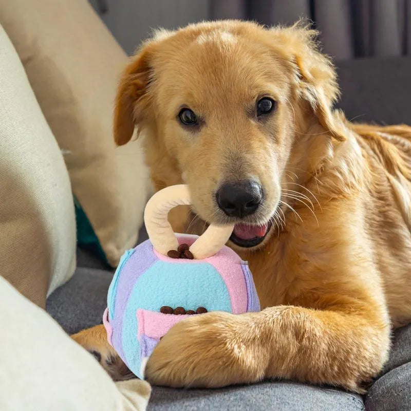 Green and pink polyester plush squeaky ball dog toy with snuffle pockets for treats.