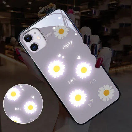 White Apple iPhone case with painted daisy pattern and illuminated voice-activated colour light on display.