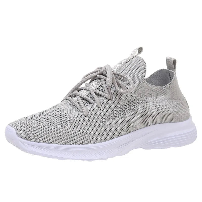 Women's low-top running shoes in creamy white with Flyknit upper and flat rubber sole.