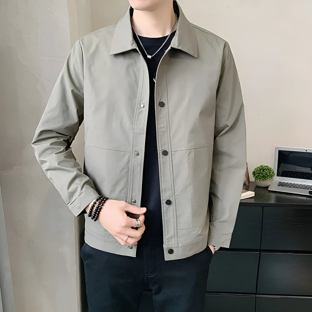 Man wearing a thin, single-layer Korean-style jacket in light grey, showcasing long sleeves and a casual fit.
