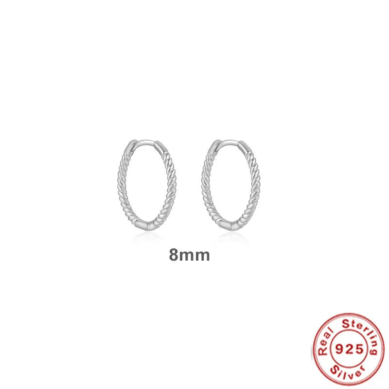 Close-up of twisted sterling silver hoop earrings showing the textured string design.