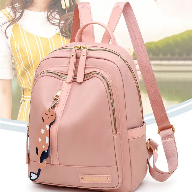 Black women's casual nylon backpack with soft handle and shoulder straps showing internal compartments