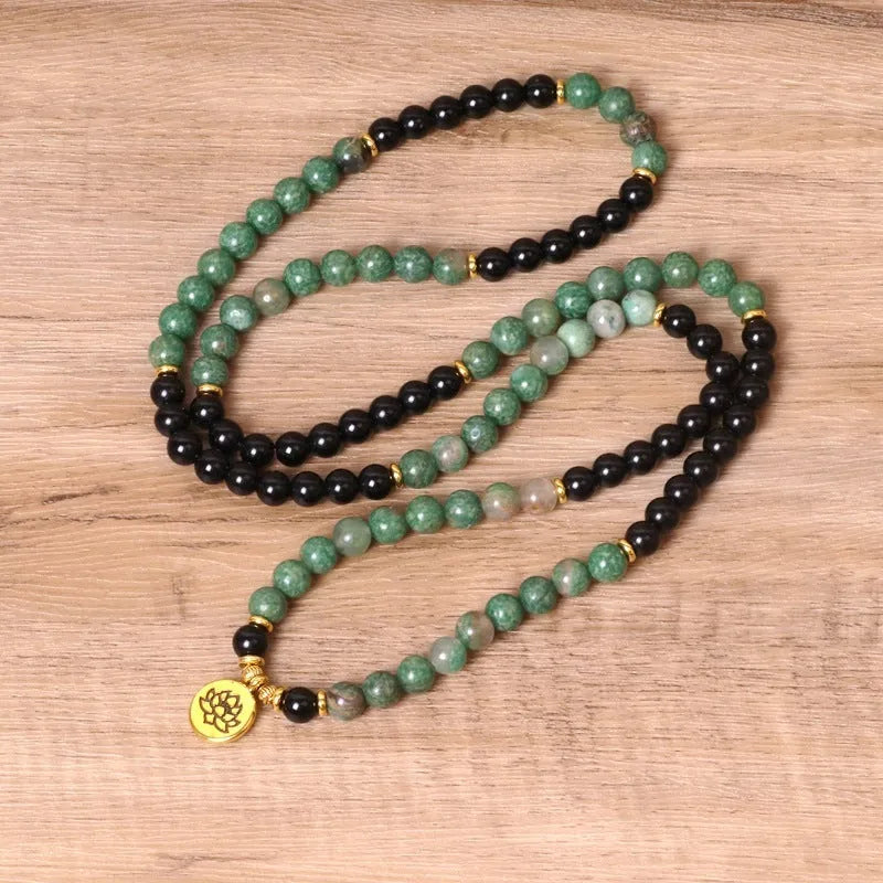 Green and black alloy elastic beaded bracelet with charm decorations on a stretch band.