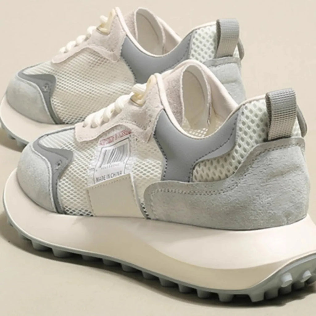 Women's grey retro low-top sneaker with round toe and flat rubber sole on a neutral background.
