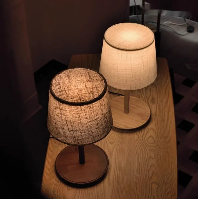 Walnut-coloured solid wood bedside lamp with white cloth shade and cable switch