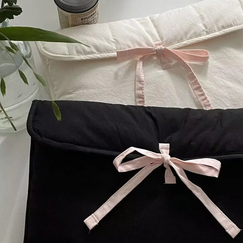 Women's black quilted computer bag with striped pattern and ballet bow detail