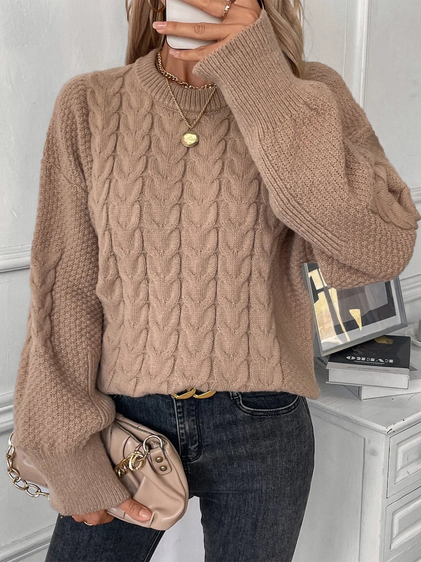 A woman's loose-fit round neck sweater in a solid colour, shown in a casual street fashion style.