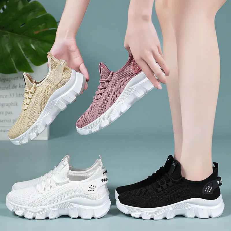 Women's white Flyknit sneakers with thick PVC sole and lace-up fastening on a neutral background.