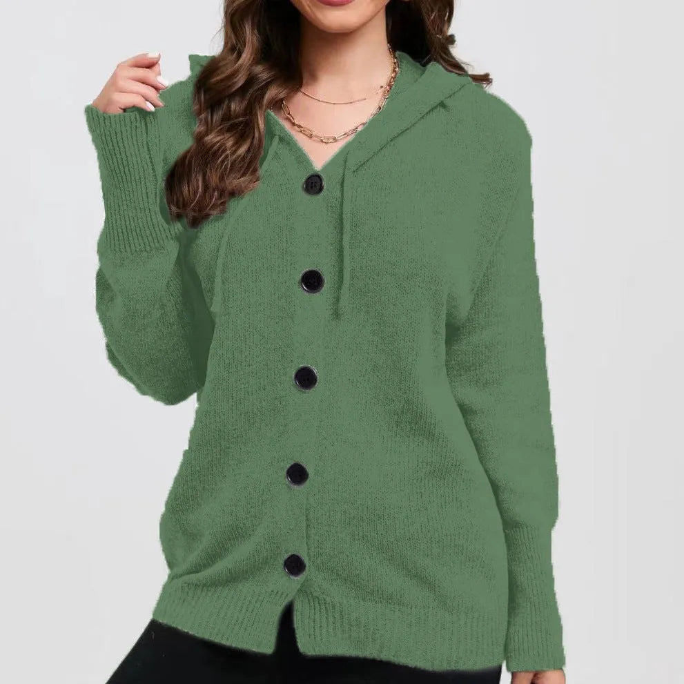 Woman wearing a thick, loose-fit hooded cardigan sweater in a solid colour.