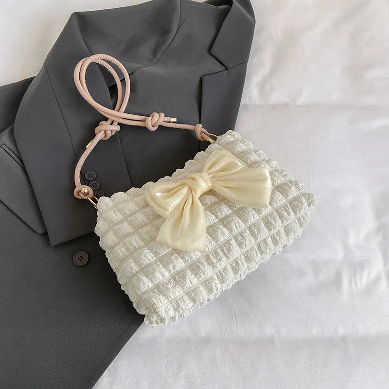 Women's one-shoulder canvas handbag in horizontal square shape with single strap.
