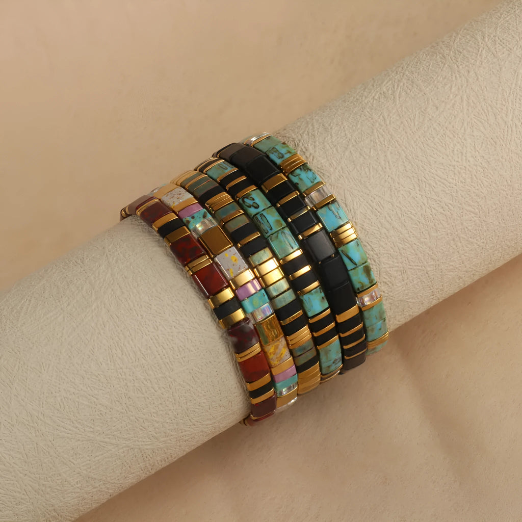 Geometric glass and coloured glaze beaded bracelet in milky white, black, green, blue, or red.