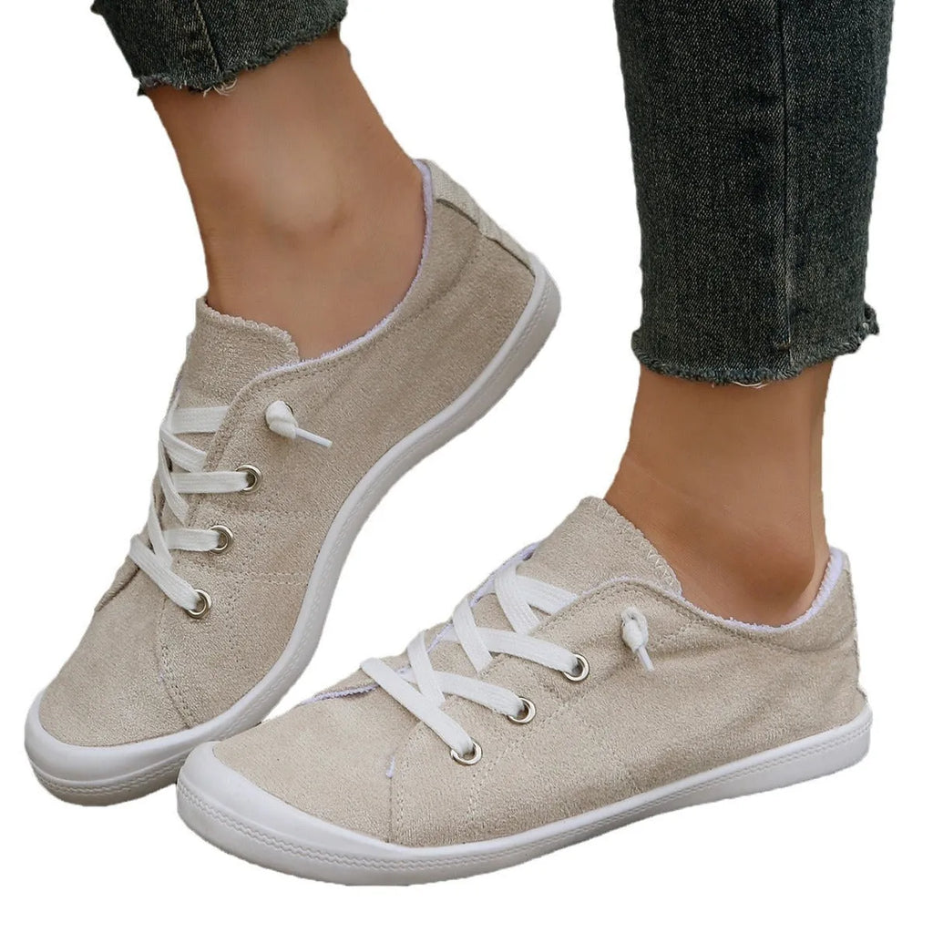 Women's creamy white casual low-top sneaker with soft fabric upper and rubber sole.