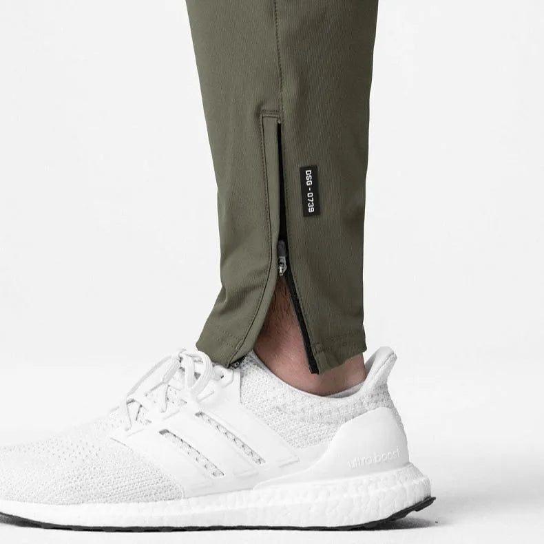 Men's grey quick-dry fitness pants with ankle ties shown in loose fit for exercise